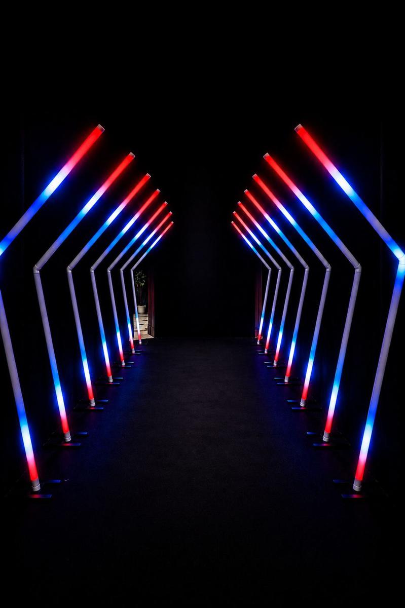 Túnel de LED com setas em rosa e azul